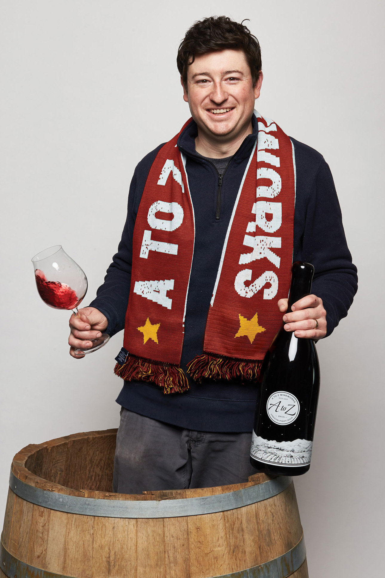 Fred in barrel with wine bottle and wine glass, wearing A to Z scarf
